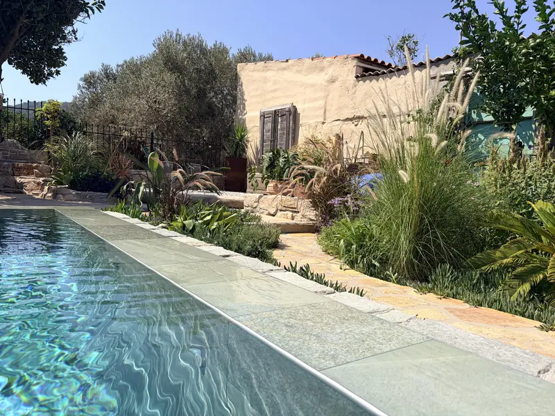 The pool with the garden and the old wooden shutters of the house